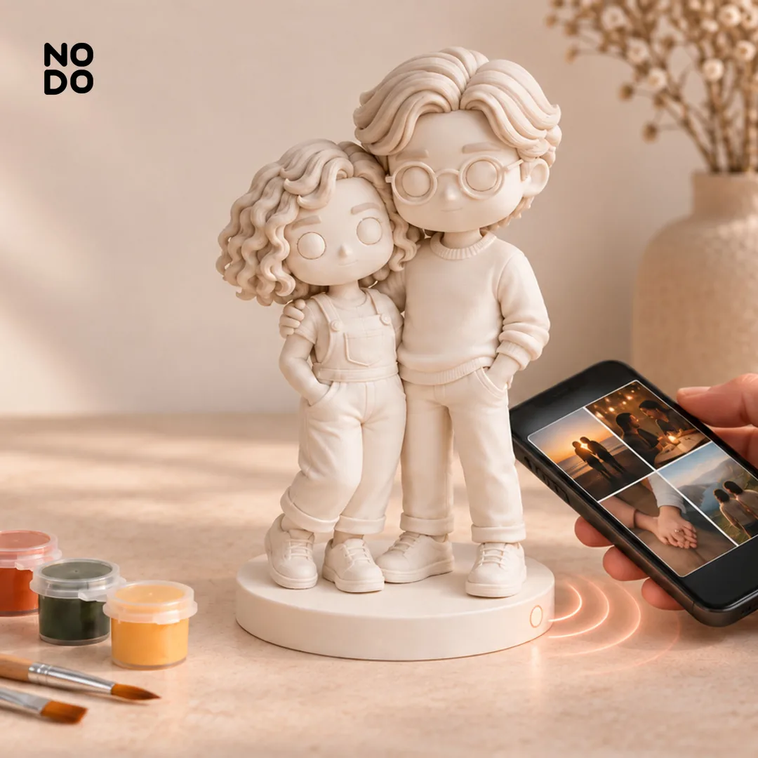 Figuras 3D de una pareja sin pintar, con pinturas y un celular abriendo el álbum